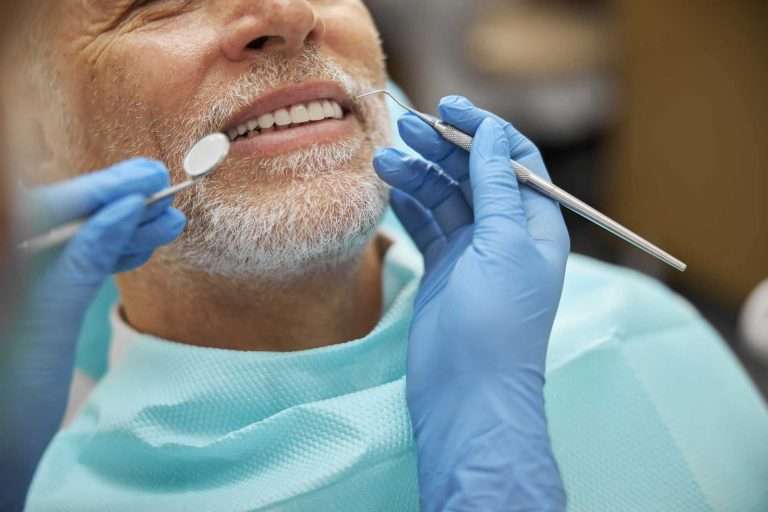 Male patient in a dentist chair smiling with white shiny teeth